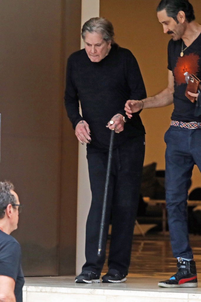 Ozzy Osbourne gets help down the stairs as he leaves Milk Studios in Los Angeles.