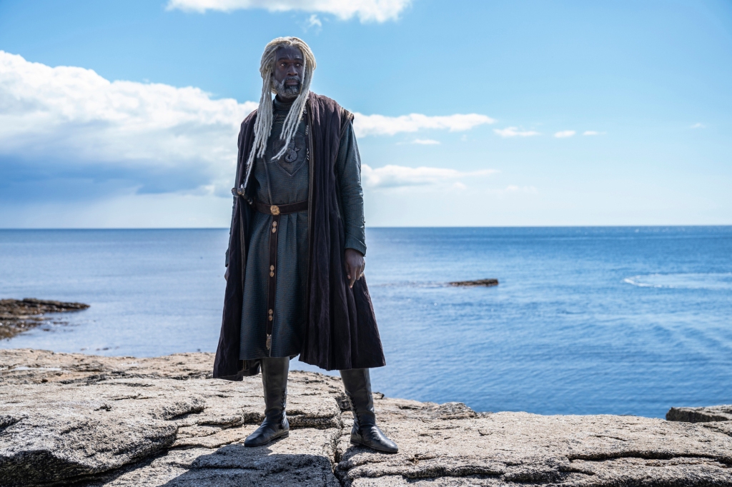 Lord Corlys Velaryon (Steve Toussaint) standing on a cliff by the sea in "House of the Dragon." 