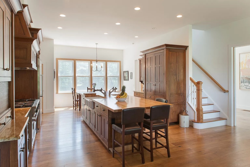 A wide shot of the kitchen shows a second staircase to the second floor.