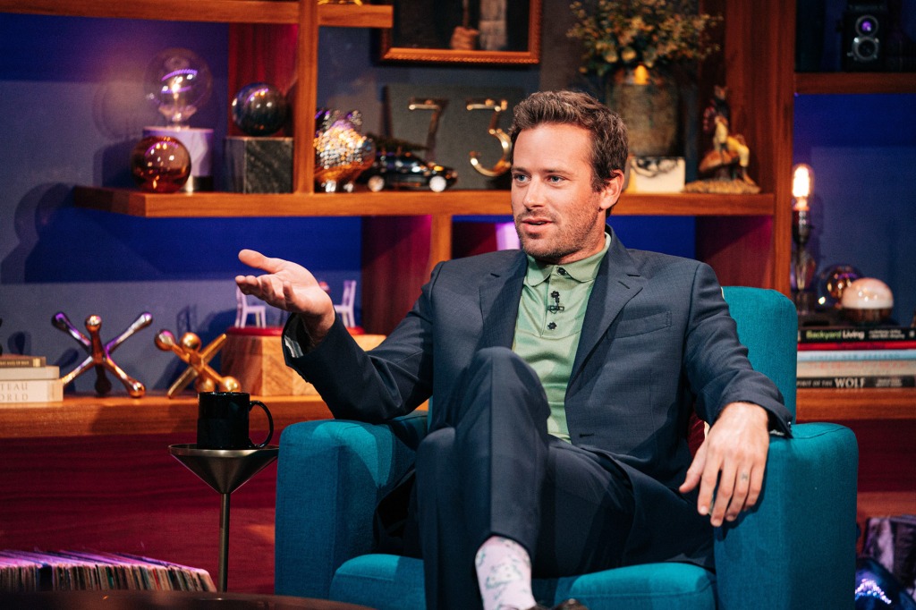 Armie Hammer sits on a couch during a television appearance. 