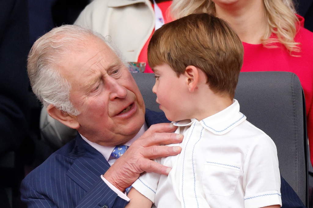 Prince Louis of Cambridge sits on the lap of his grandfather Prince Charles, Prince of Wales, as they attend the Platinum Pageant on The Mall on June 5, 2022 in London, England. 