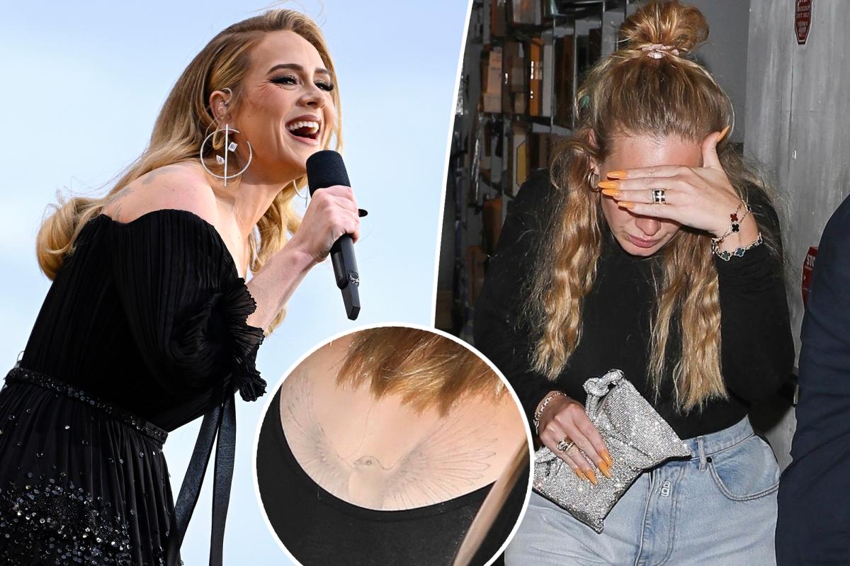 Adele appears to be removing her tattoo on the back